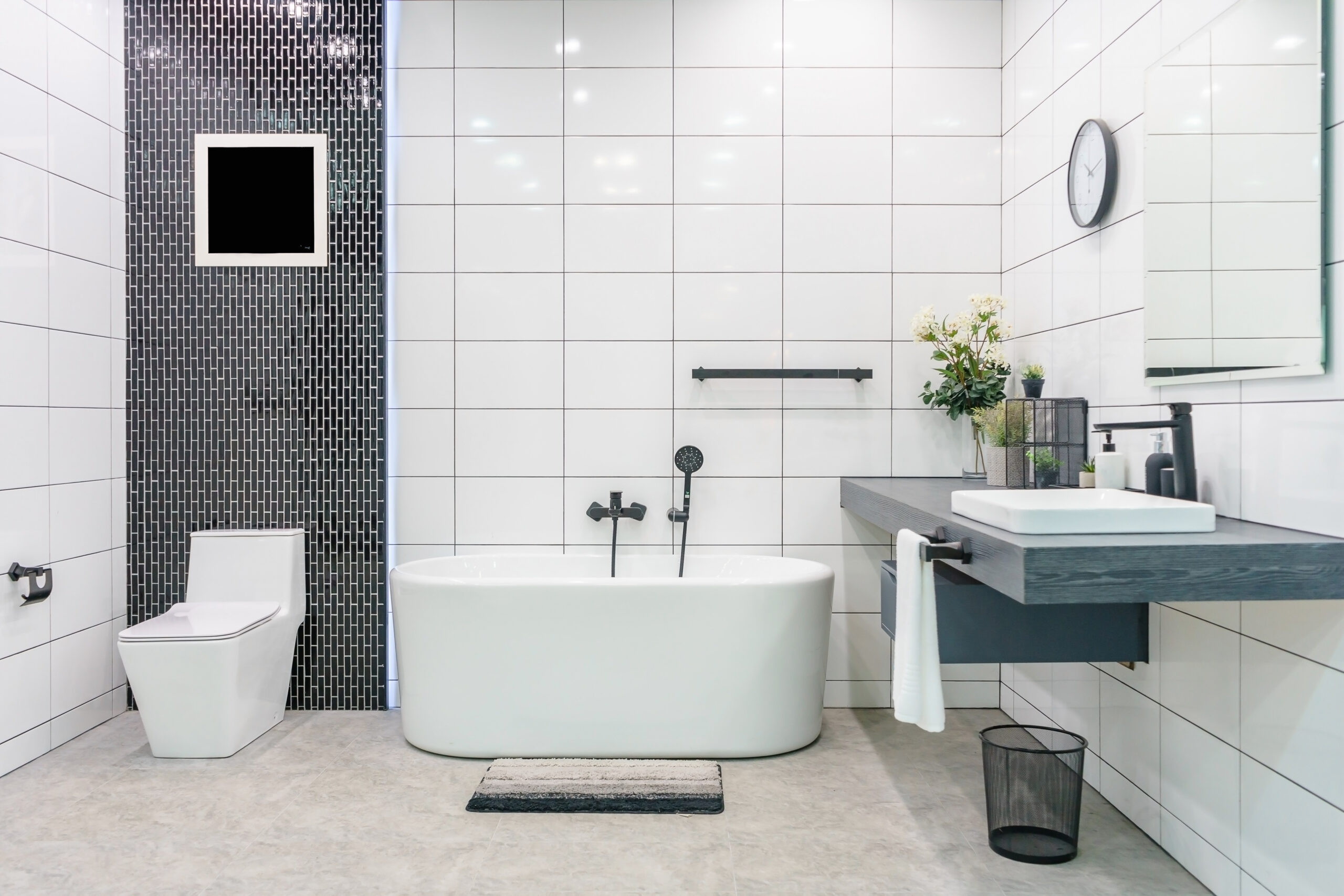 Modern bathroom interior with minimalistic shower and lighting, white toilet, sink and bathtub